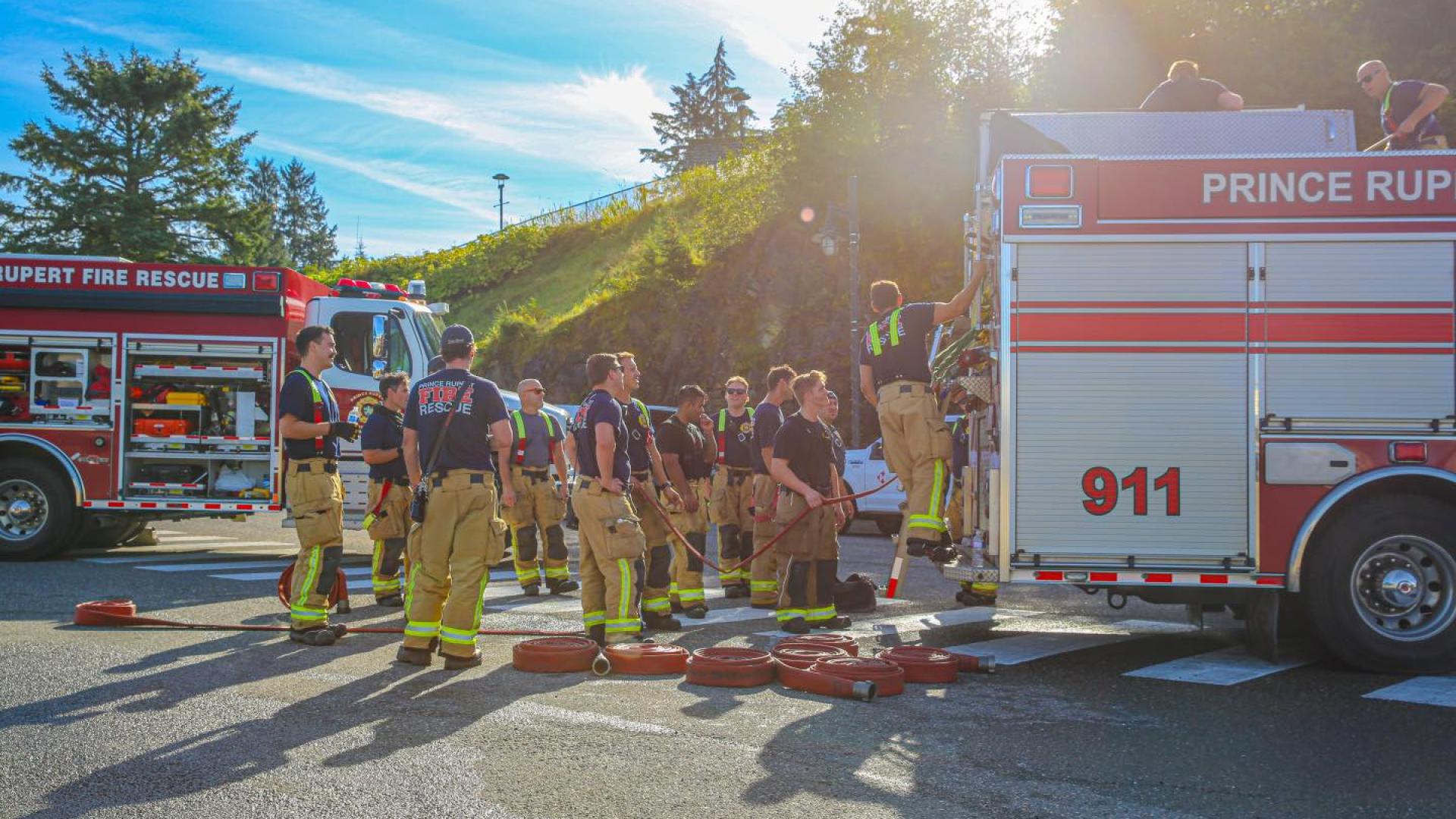Prince Rupert firefighters standing in front of two fire trucks