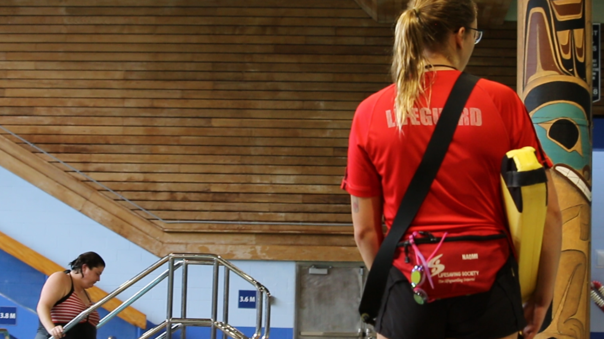 lifeguard at the Prince Rupert swimming pool with their back to the camera